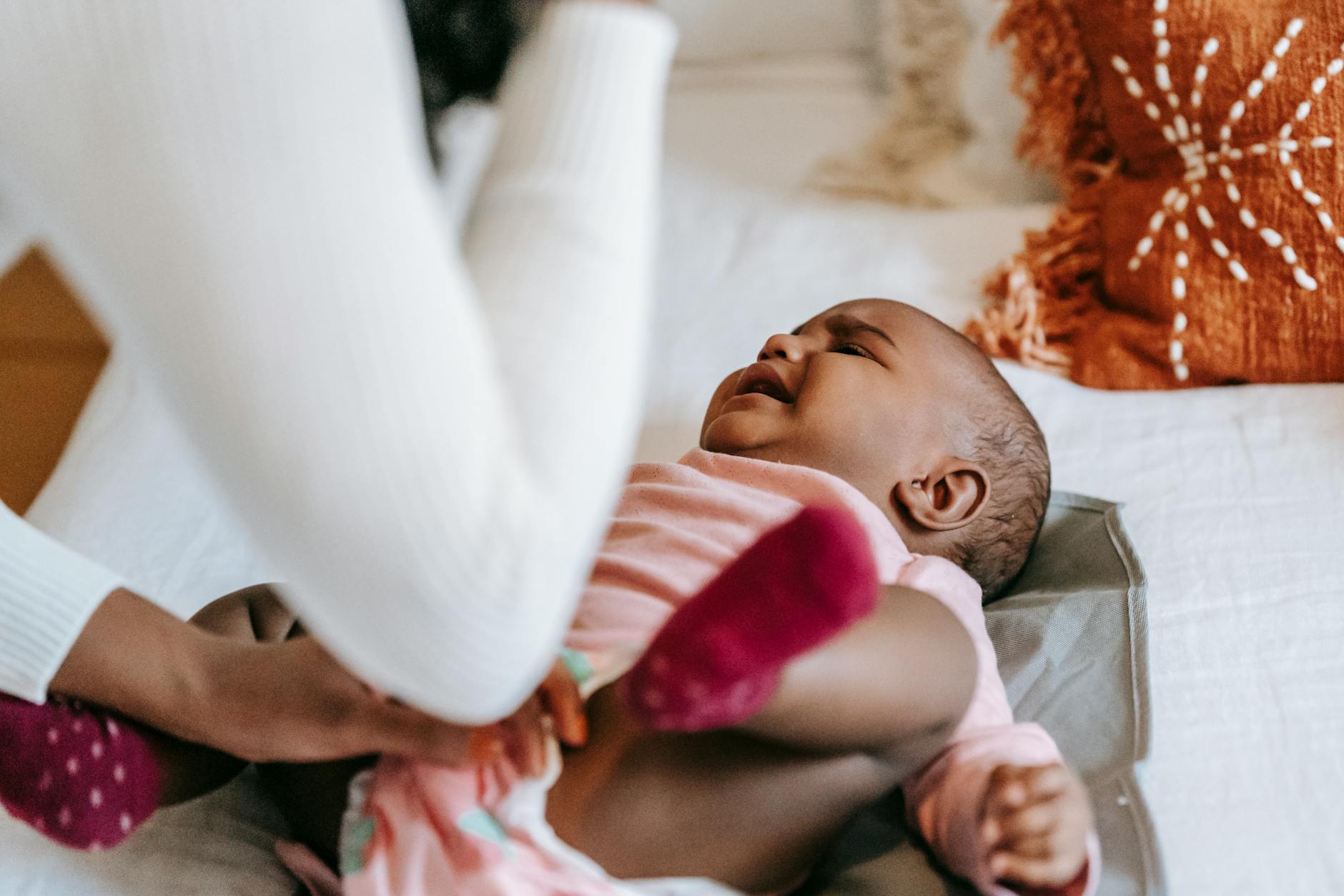 mother soothing cute crying little black daughter
