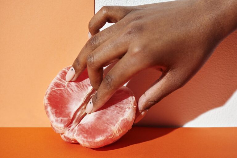 a close up shot of a person touching a grapefruit